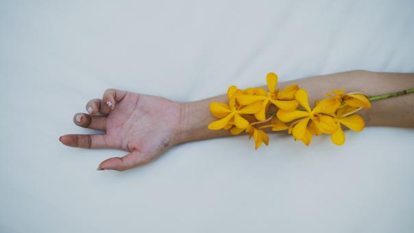 Free Stock Photo of A Woman With Yellow Flowers On Her Arm