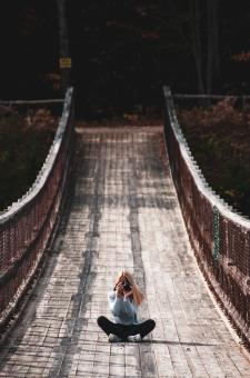 Free Stock Photo of Girl with Camera Sitting on Bridge