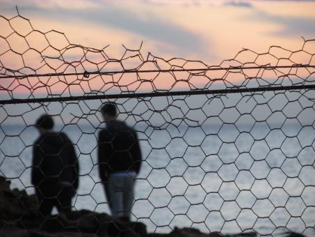 Free Stock Photo of Sunset walk Behind the Fence