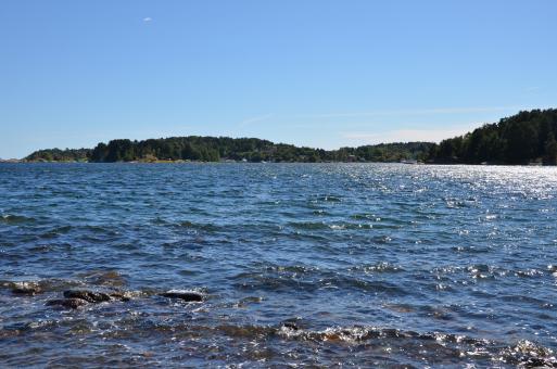 Free Stock Photo of A seaview to a fjord, with on the backgroud and blue sky