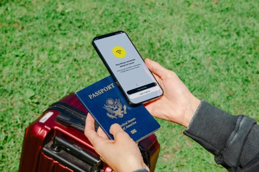 Free Stock Photo of A close-up of a hand holding a U.S. passport and a smartphone