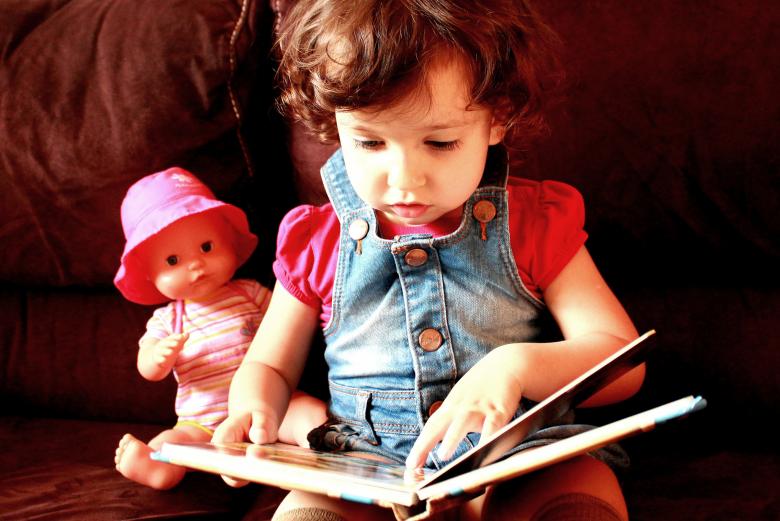 Free stock image of Child reading a book with doll created by Jack Moreh