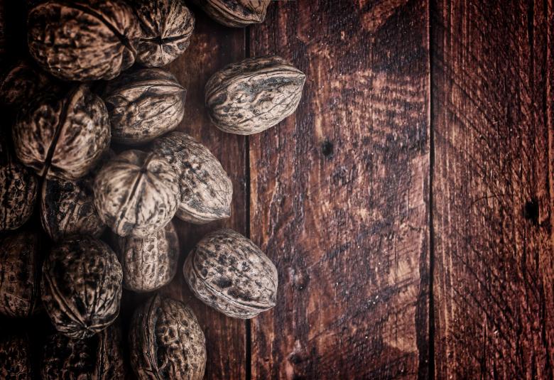 Free stock image of Whole walnuts on rustic old wooden table - With copyspace created by Jack Moreh