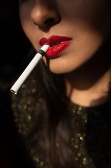 Beautiful young blonde girl smokes a white cigarette - Free Stock Photo
