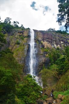 Tropical waterfall falls from the mountain cliff to the jungle - Free Stock Photo