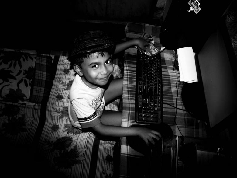 Free stock image of Smiling Boy Using Computer - Black and White created by Moon  Bhuyan