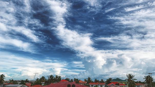 Blue Sky and Clouds Over Buildings - Free Stock Photo