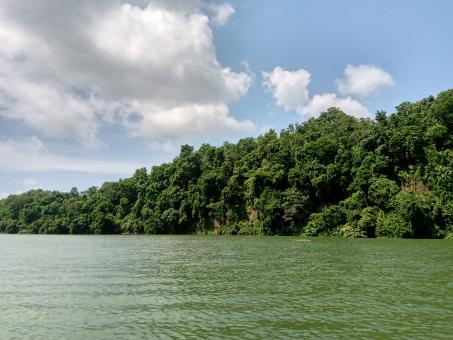 The reflection of green hill and cloudy sky in the water - Free Stock Photo