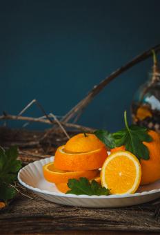 Cut Orange On A Plate On A Wooden Table Stock Photo - Free Stock Photo