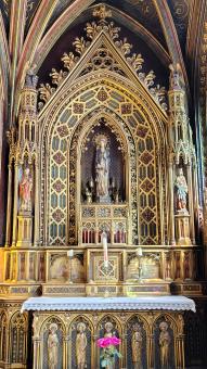 Gothic Cathedral Interior with Ornate Gold Altar and Stained Glass