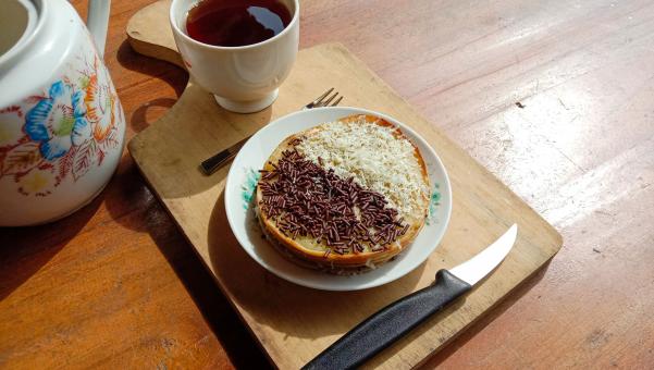 A mini photo of a martabak with a chocolate topping and grated c