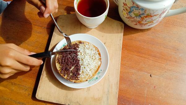 A mini photo of a martabak with a chocolate topping and grated c