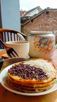 A mini photo of a martabak with a chocolate topping and grated c