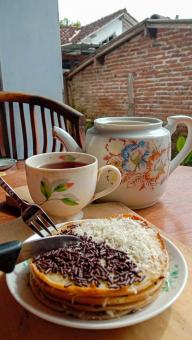 A mini photo of a martabak with a chocolate topping and grated c