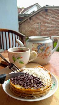 A mini photo of a martabak with a chocolate topping and grated c