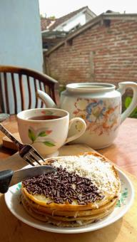 A mini photo of a martabak with a chocolate topping and grated c