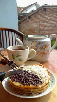 A mini photo of a martabak with a chocolate topping and grated c
